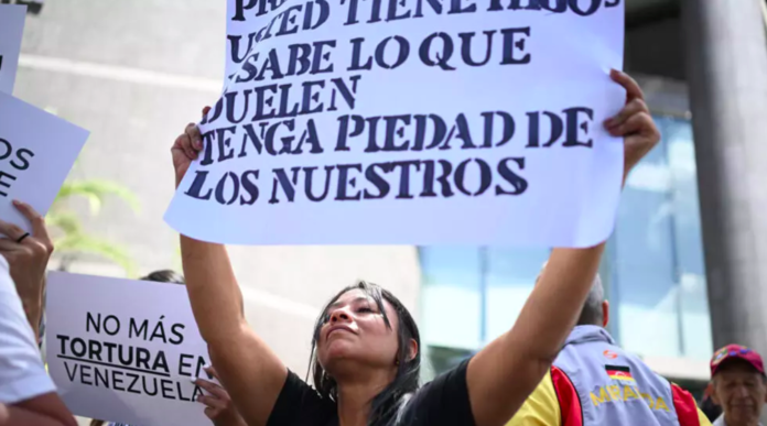 Una mujer sostiene una pancarta para pedir la libertad de los adolescentes detenidos en Venezuela tras las manifestaciones contra la reelección del presidente Nicolás Maduro, en Caracas el 21 de octubre de 2024 © Federico PARRA / AFP